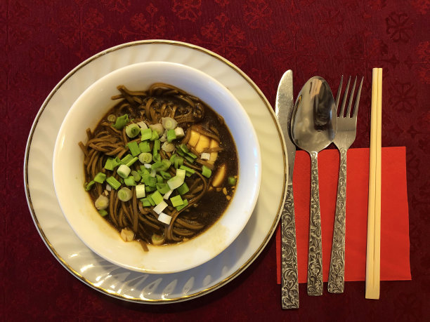 红桌布上放着一盘面汤图片下载