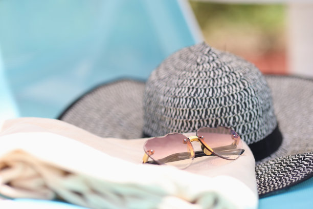 时尚的帽子和太阳镜放在阳光躺椅上图片下载