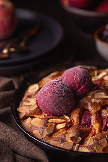 特写的浆果冰沙上的水果蛋糕与桃子，浆果和杏仁。黑暗情绪的照片。垂直的图像。图片下载