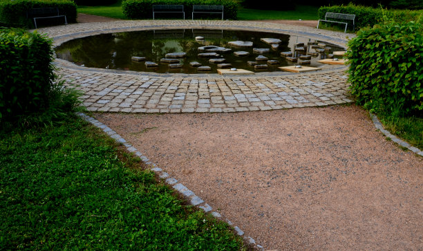 有喷水装置的圆形喷泉。海滨平缓，夏季适合儿童作为嬉水池。它们能跳过不规则的石头。地震火山口充满了水。公园图片下载