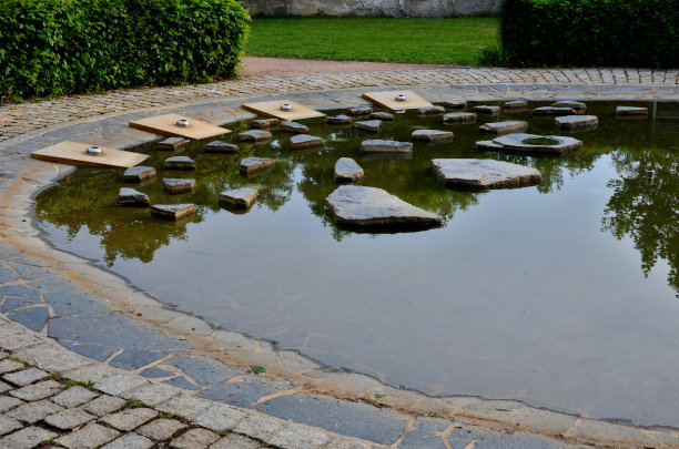 有喷水装置的圆形喷泉。海滨平缓，夏季适合儿童作为嬉水池。它们能跳过不规则的石头。地震火山口充满了水。公园图片下载