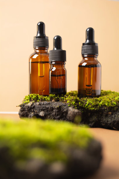 化妆品瓶在混凝土石头上，米色背景上有苔藓图片下载