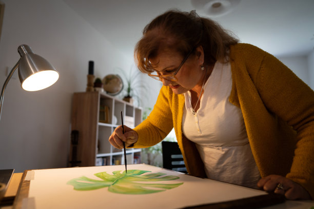 年长的白人妇女在家画画图片下载