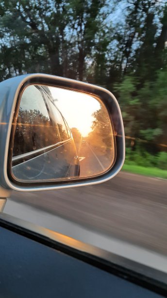 夕阳映照在汽车的镜子里图片下载