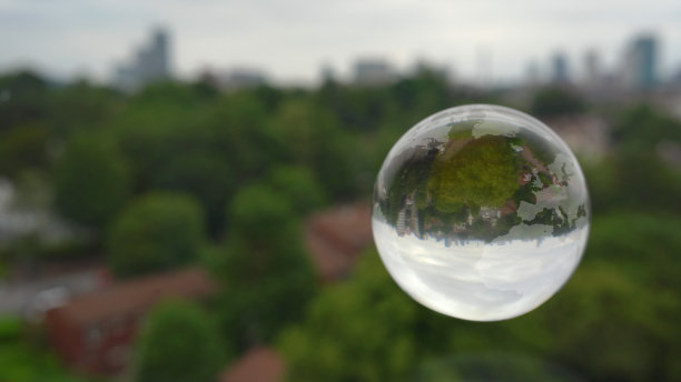 以城市为背景的漂浮玻璃地球。图片下载