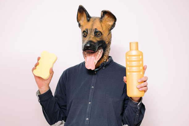 戴狗面具的人展示海绵和沐浴露图片下载