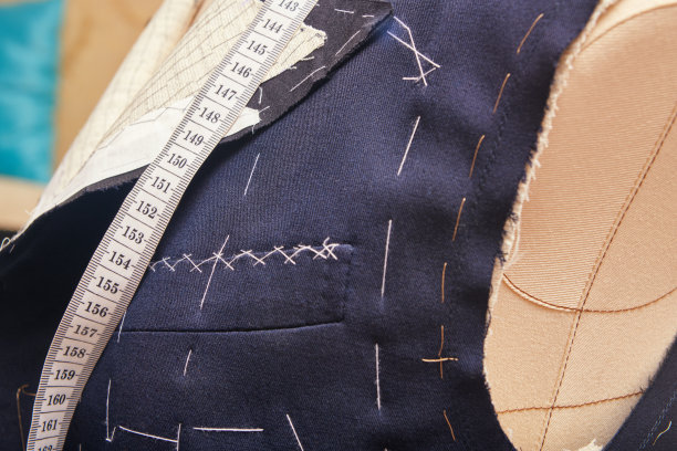 缝胸口袋半准备西装夹克。西装裁剪过程中的定制夹克。在裁缝车间定制西服。做一件量身定做的西装夹克图片下载