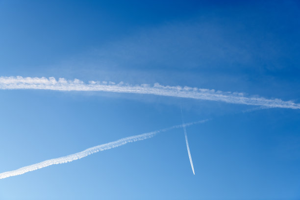 深蓝色的天空中有几道白色的凝结痕迹图片下载