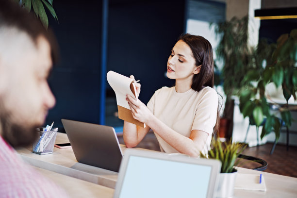 年轻迷人的女商人在记事本上做笔记在她的工作场所图片下载