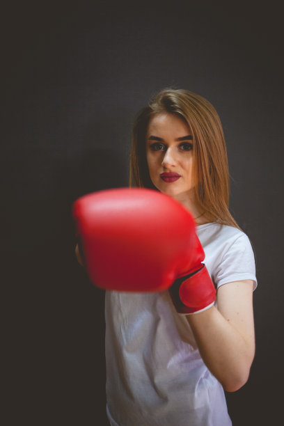 漂亮的女人拳击手在红色沙袋附近图片下载
