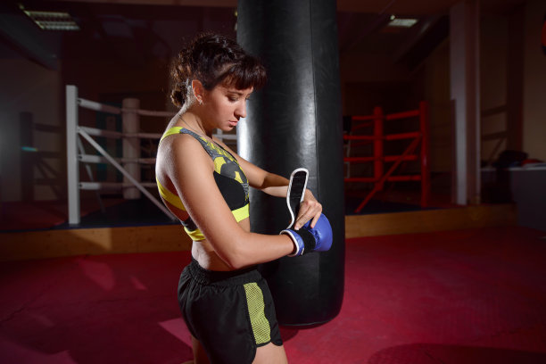女孩在体育馆里戴上拳击手套。特写图片下载