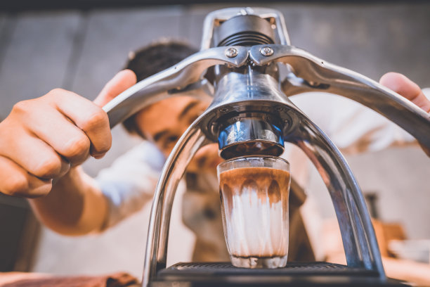 专业的咖啡师制作新鲜咖啡的热饮，在复古的咖啡馆，一杯棕色芳香热咖啡，饮料咖啡因的早晨，咖啡豆和早餐背景图片下载