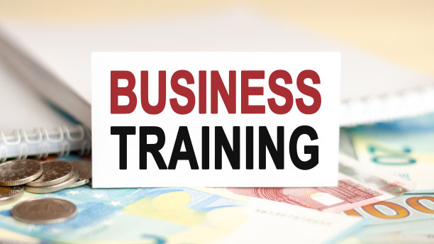 桌子上放着钞票、硬币和一个标牌，上面写着——商业培训、金融和经济概念。图片下载