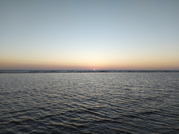 阳光在Katwijk的海滩上沉入大海，天空五彩缤纷图片下载