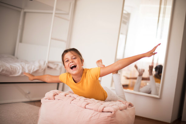 微笑的小女孩独自在卧室玩耍。图片下载