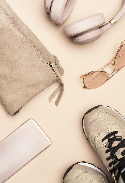 女孩潮的夏天裸粉色的东西和配件:包，运动鞋，手机，耳机，浅粉色背景太阳镜，俯视图图片下载