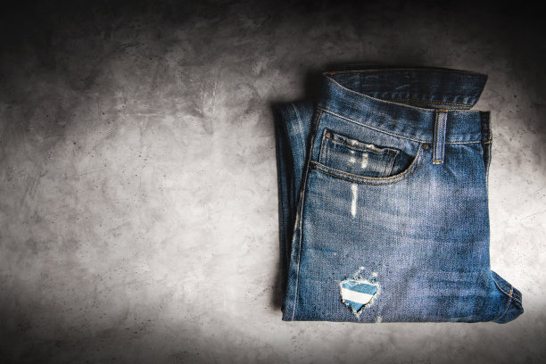 牛仔裤裤子躺在水泥地板上。时尚，任何性别的衣服，经典穿着的多样性图片下载
