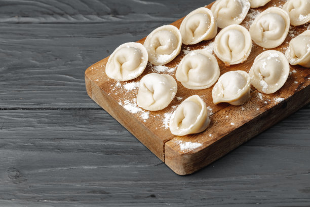 生肉饺子放在木板桌上图片下载