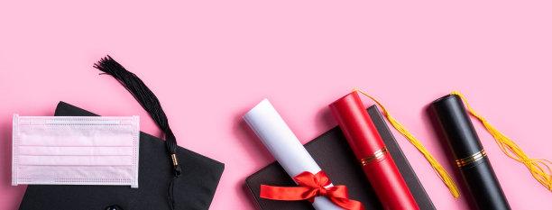 毕业学位帽与毕业文凭和面具隔离在粉红色的桌子背景上。图片下载