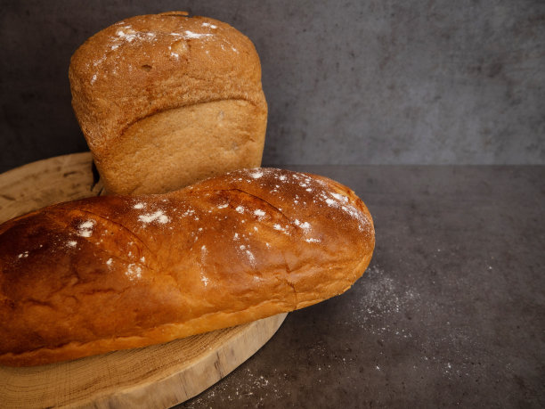 水泥灰色的桌子和木板上放着新鲜的面包。健康食品和传统烘焙理念。特写镜头。图片下载