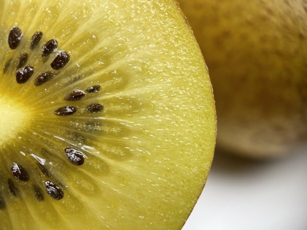 成熟的切片黄色，金色猕猴桃在白色的背景图片下载