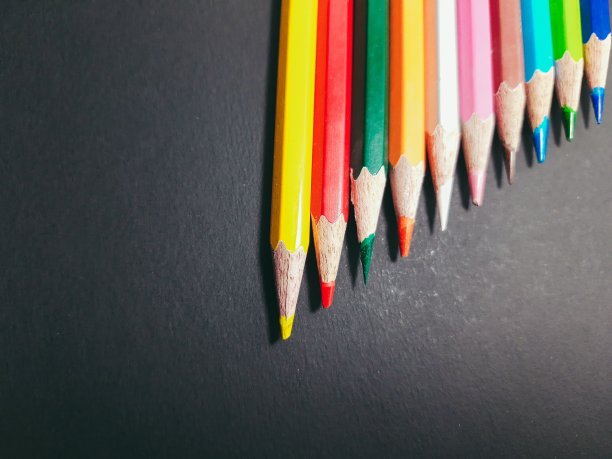 不同铅笔颜色与废弃桌面的特写镜头图片下载