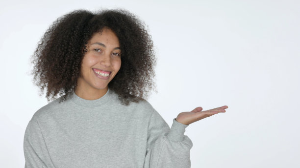 年轻的非洲妇女手持产品在掌心，白色的背景图片下载