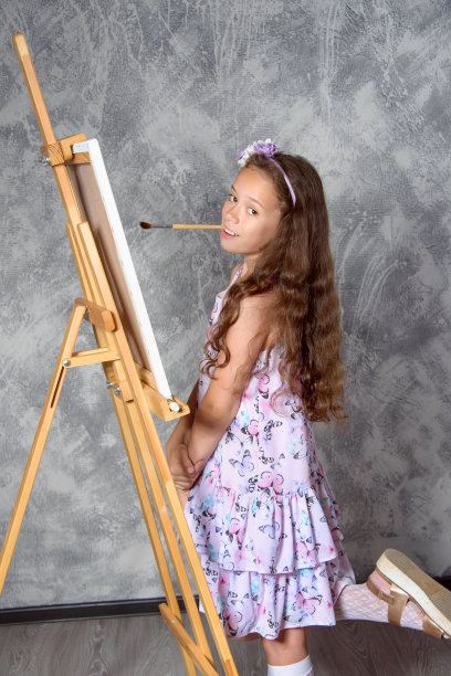 创意女孩艺术家在工作室的画架上画了一幅新画。有才华的孩子在工作室或艺术学校。图片下载
