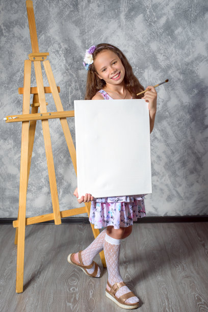 少女艺术家展示一幅画。女艺术家刚刚画了一幅画。图片是空的，你可以在其中插入你的图像。图片下载