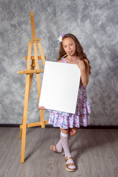 少女艺术家展示一幅画。女艺术家刚刚画了一幅画。图片是空的，你可以在其中插入你的图像。图片下载