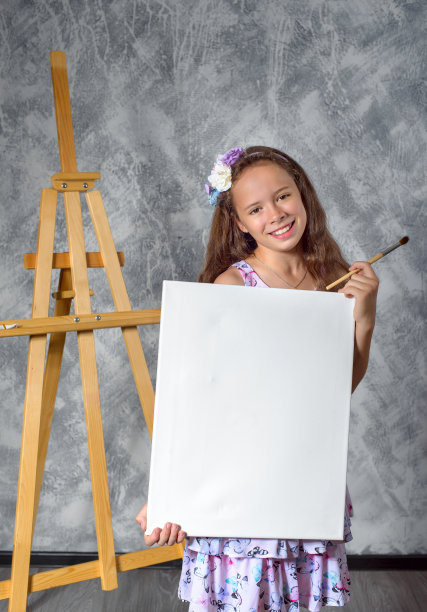 少女艺术家展示一幅画。女艺术家刚刚画了一幅画。图片是空的，你可以在其中插入你的图像。图片下载