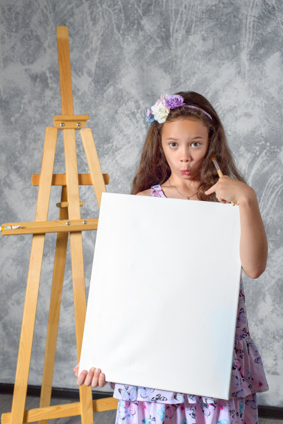 少女艺术家展示一幅画。女艺术家刚刚画了一幅画。图片是空的，你可以在其中插入你的图像。图片下载