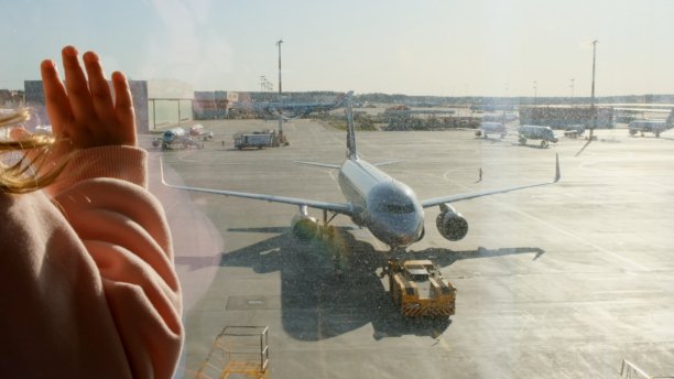 小女孩看着通过登机口的窗户停在莫斯科机场的飞机。维修和准备该团的飞机。假期，旅行，期望和梦想的概念图片下载