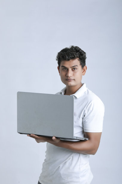 年轻的印度人在用笔记本电脑。图片下载