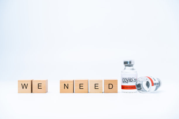 COVID-19概念与木块上的一个词“我们需要疫苗”图片下载