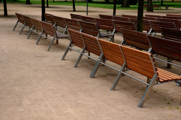 户外剧院礼堂。一排排的长凳。邻边。在这些木凳之间有一条小巷。公园沙路径。图片下载