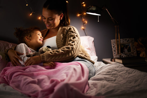 这是一位年轻的母亲在女儿睡觉前和她在一起的照片图片下载