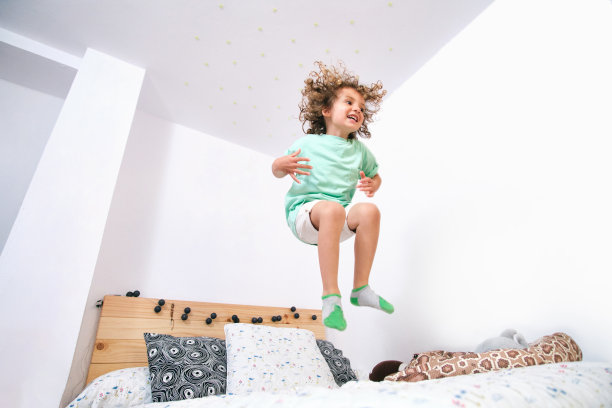 西班牙血统的孩子在床上跳图片下载