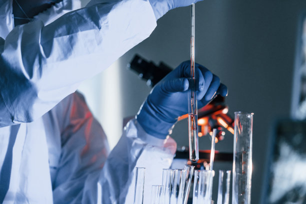 身穿白色防护服的科学家在实验室处理冠状病毒和血管图片下载