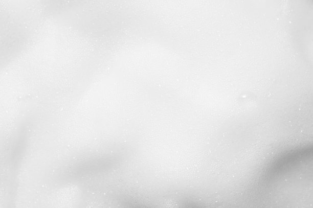 白色泡沫纹理接近背景。肥皂物质与泡沫的背景。奶油洗发水表面。沐浴露、洗涤液涂抹墙纸。化妆品泡沫污点图片下载