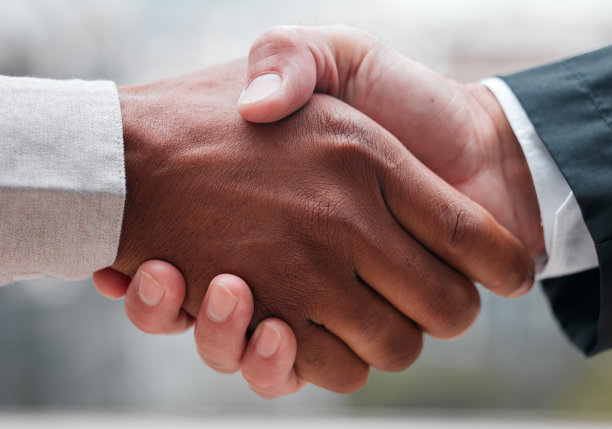 镜头中，两位面目全非的商人站在办公室握手图片下载