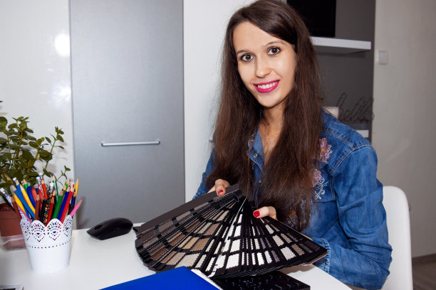 一个微笑的室内，时装设计师正在向客户展示色板。图片下载