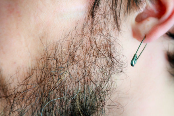 一个留着胡子的男人的特写，耳朵上有一个安全别针图片下载