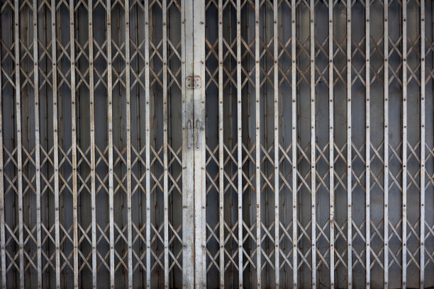 前视图金属滑动卷帘前门的老式亚洲(泰国和中国)房子与生锈和纹理显示复古的细节，复古的篱笆是美丽的背景。图片下载