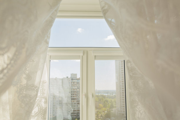 透过透明薄纱窗帘的客厅窗户。这张照片是在阳光明媚的早晨拍摄的图片下载