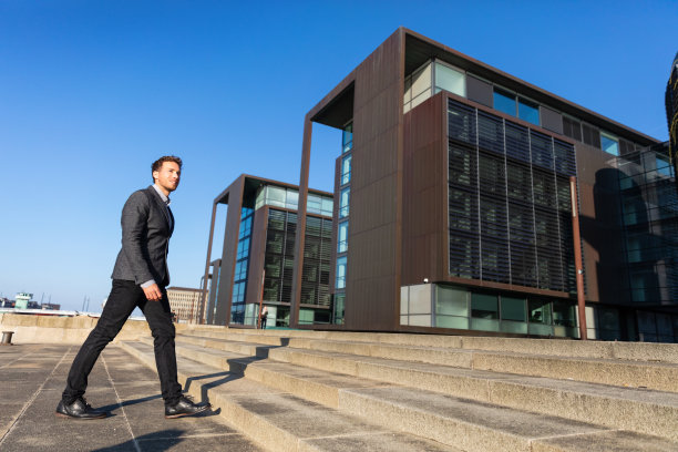 年轻的商人每天早上步行上班，在哥本哈根城市的街道上上班，城市人通勤的生活方式。快乐的商人穿着西装在秋天或春天图片下载