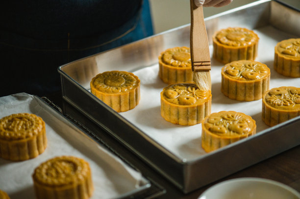 面包师在烤盘上用鸡蛋面团画自制月饼图片下载