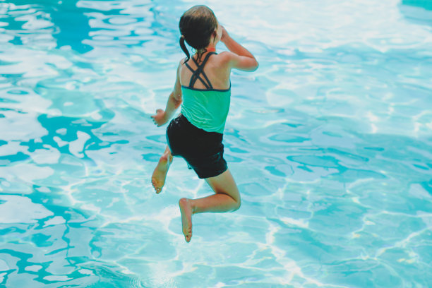 小女孩在游泳池里蹦蹦跳跳图片下载