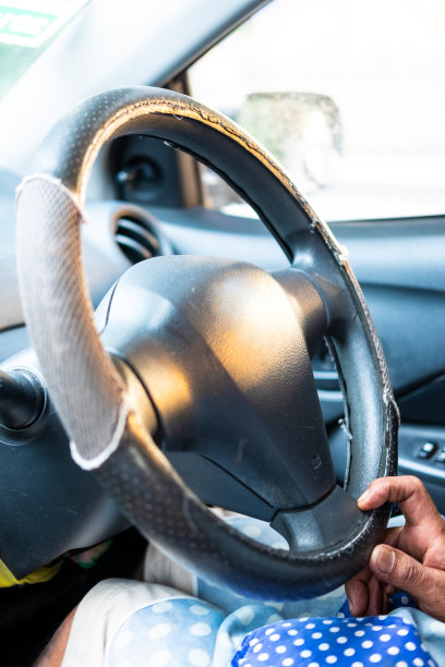 一个高级男子的特写手在他的汽车方向盘上，一个汽车方向盘。图片下载