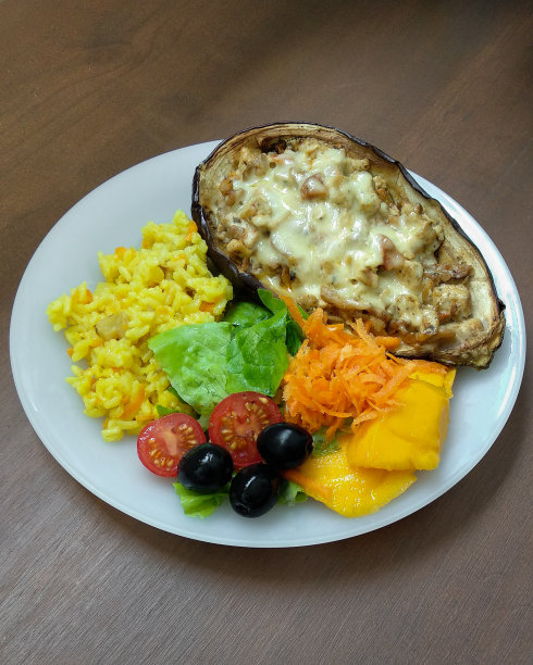 酿烤茄子配沙拉和米饭。素食菜图片下载